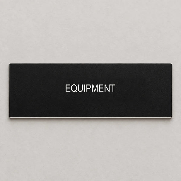 Black plastic engraved nameplate with white EQUIPMENT text